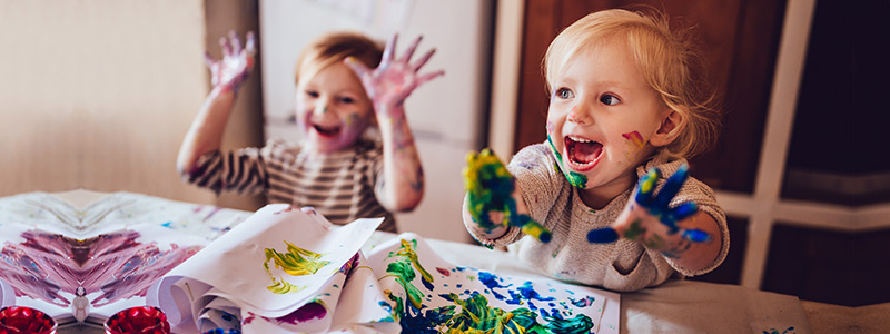 Guide to Junior ISAs for these children playing with paint